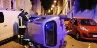 Via Buonarroti, sbatte contro le auto parcheggiate e si cappotta