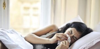 Immagine di una donna allergica ai pollini che si soffia il naso