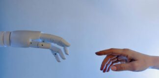 Immagine di una mano umana e una mano robotica: dipendenza da intelligenza artificiale