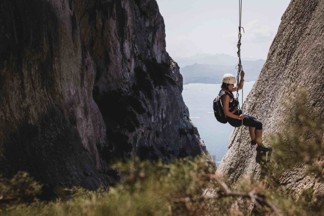 Immagine di una turista che fa arrampicata sulla roccia; turismo esperienziale