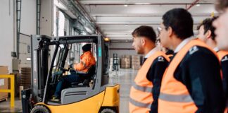 studenti dell'accademia nautica dell'adriatico durante una visita didattica in un magazzino di logistica. un operatore muove un muletto