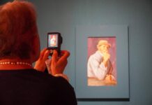 Loreto Bertoli dialoga con i grandi maestri del Novecento: a Tolmezzo opere di Picasso, Gauguin e Kokoschka Signora fotografa un quadro alla mostra "La poesia dello sguardo".