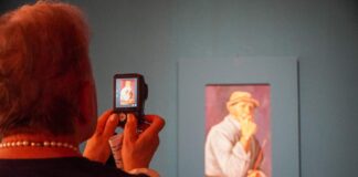 Signora fotografa un quadro alla mostra "La poesia dello sguardo".