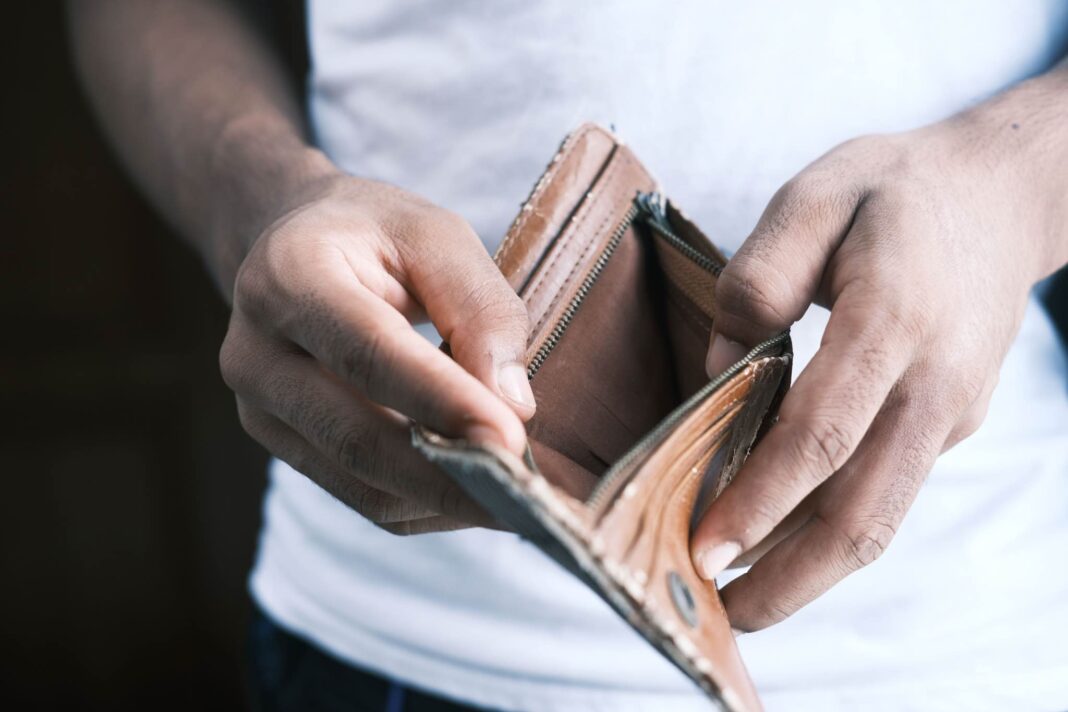 Persona tiene in mano un portafogli vuoto: immagine utilizzata per un articolo sul Rapporto Caritas povertà in Italia 2026