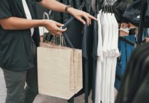 Saldi estivi 2026, Confcommercio registra un +3% nel primo giorno di vendite ragazzo fa shopping in un negozio di abbigliamento