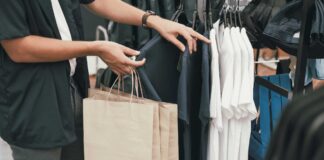 Saldi estivi 2026, Confcommercio registra un +3% nel primo giorno di vendite ragazzo fa shopping in un negozio di abbigliamento