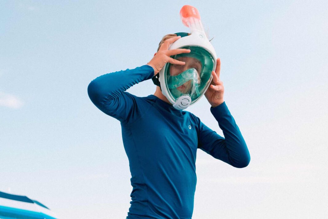Bambino in spiaggia si prepara a fare snorkeling con la maschera full face