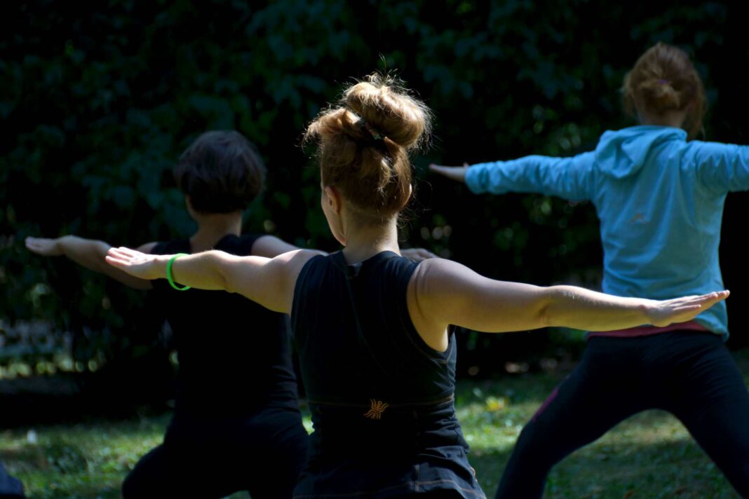 Tre persone fanno yoga all'aperto a Trieste